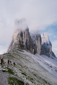 Group of people on rock against sky