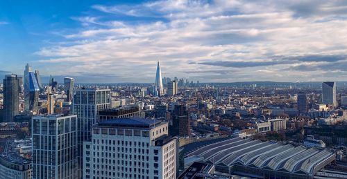 High angle view of buildings in city against cloudy sky