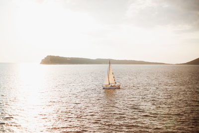 Sailboat sailing on sea against sky