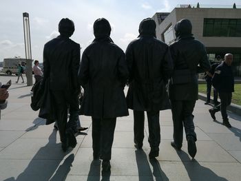 Rear view of people walking on footpath