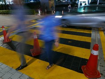 Blurred motion of woman walking on street in city