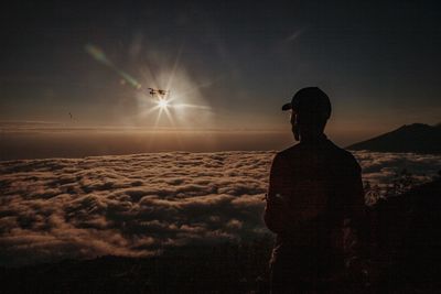 Silhouette man looking at view against sky during sunset