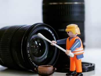 Close-up of toy and camera lens on table