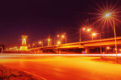 Illuminated light trails on road against sky at night