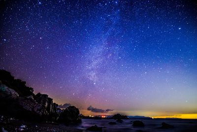 Scenic view of sea against star field at night