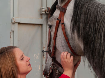 Woman with horse against metal structure