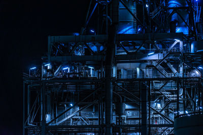 Low angle view of illuminated industry at night