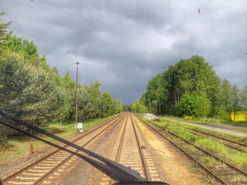 Railroad track against cloudy sky