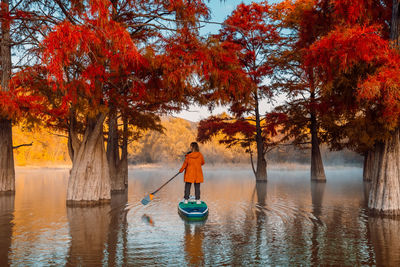 Rear view of woman standing in lake