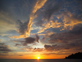 Scenic view of sea against dramatic sky during sunset