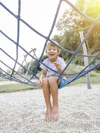 Portrait of boy playing on jungle gym at park