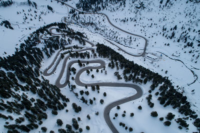 Aerial view of winding road amidst trees during winter