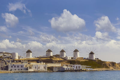 Buildings by sea against sky