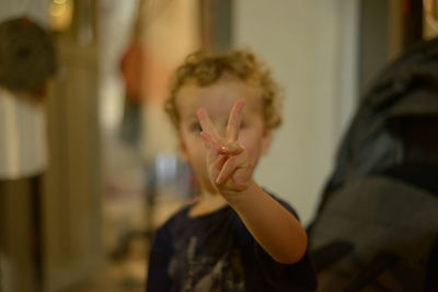 Boy gesturing over face at home