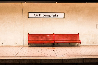 Empty bench at illuminated railroad station