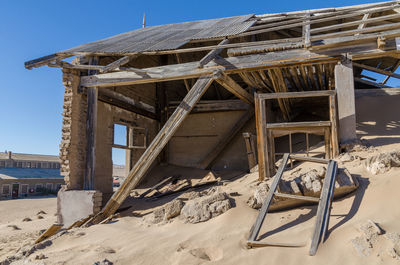 Abandoned buiding in desert against sky at ghost town kolmanskop, namibia