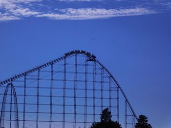 Low angle view of ferris wheel against blue sky