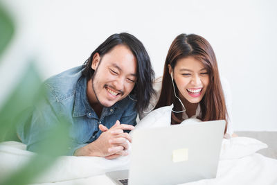 Portrait of a smiling young woman using phone