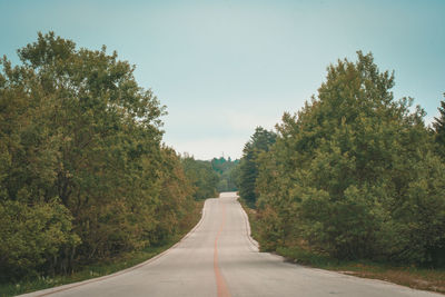 Road amidst trees against sky