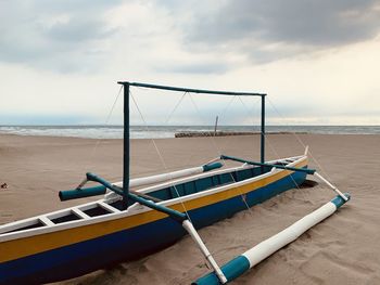 Boats moored on beach against sky