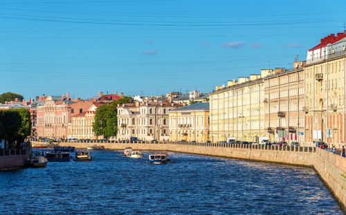 View of river in city against blue sky