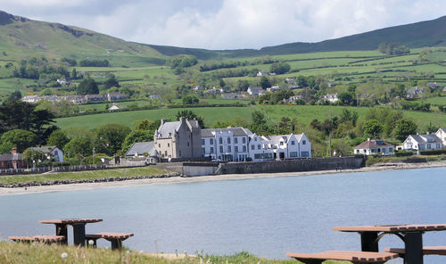 Scenic view of river by buildings against sky