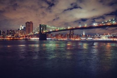 River with illuminated bridge in distance