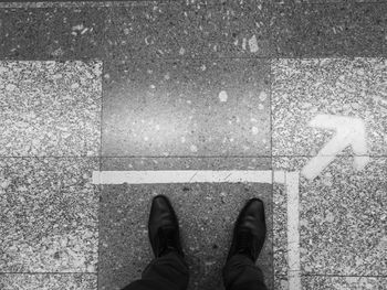 Low section of man standing on road