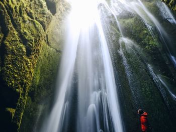 Low angle view of waterfall in forest against sky
