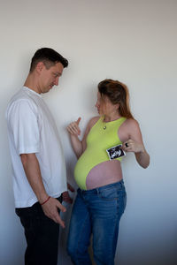 Side view of couple standing against wall