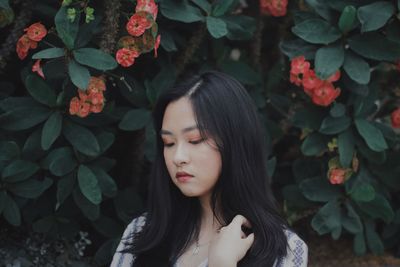 Close-up of beautiful young woman standing by plants