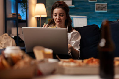 Portrait of woman using laptop at table