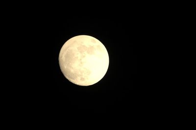 Low angle view of full moon against clear sky at night