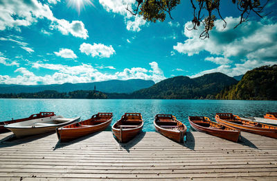 Boats moored in lake against sky