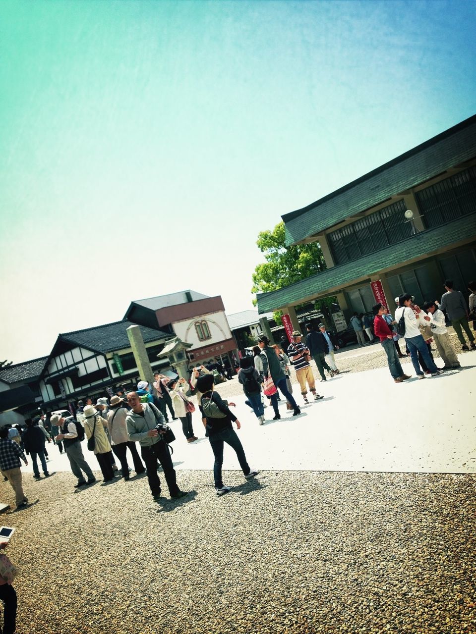 large group of people, men, lifestyles, person, building exterior, leisure activity, architecture, built structure, street, walking, clear sky, city, city life, sky, mixed age range, crowd, togetherness, sunlight, outdoors