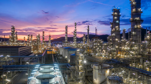 Aerial view oil and gas tank with oil refinery background at night, glitter lighting petrochemical.