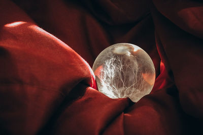 Close-up of crystal ball on brown fabric