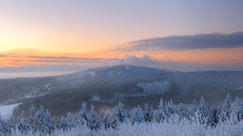 Scenic view of snow field against sky during sunset