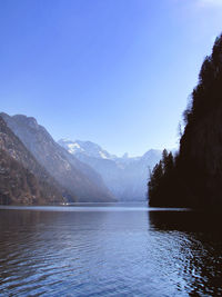 Scenic view of lake and mountains against blue sky