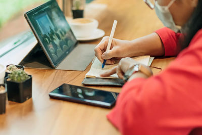 Midsection of man using laptop on table