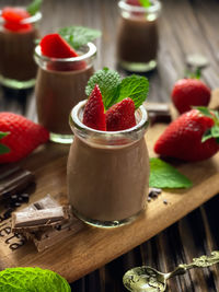 Close-up of strawberries on mousse dessert in glass on table