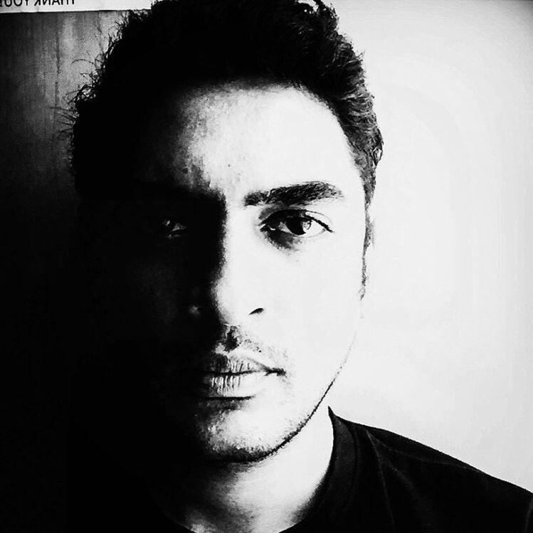 CLOSE-UP PORTRAIT OF HANDSOME YOUNG MAN AGAINST WHITE BACKGROUND