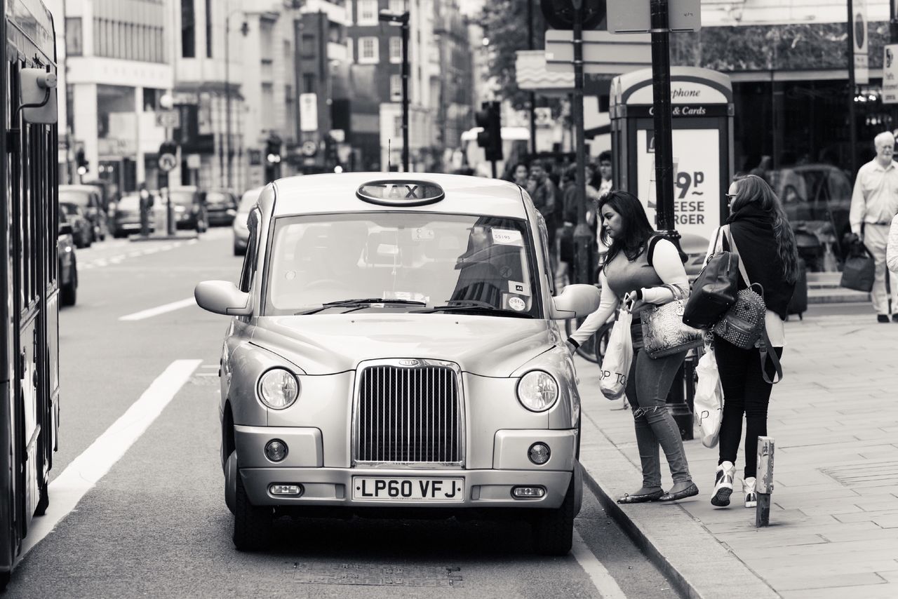 street, city, building exterior, city life, architecture, transportation, car, men, built structure, walking, city street, land vehicle, person, incidental people, road, text, lifestyles, rear view, mode of transport