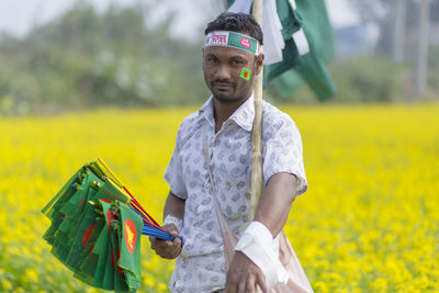 Portrait of young man standing on field