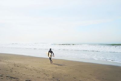 Full length of woman on beach against sky