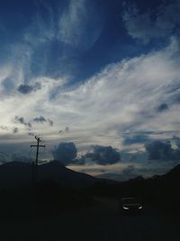 Silhouette car on mountain against sky at dusk