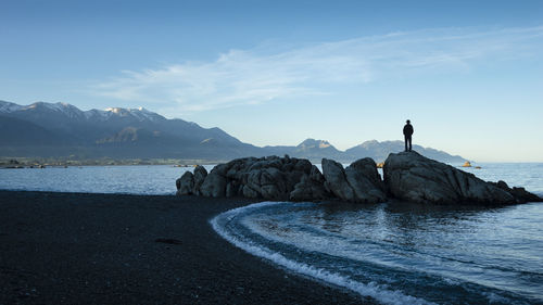 Scenic view of sea and mountains against sky