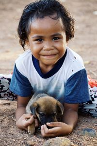 Portrait of boy with dog sitting on ground