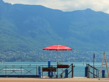 Scenic view of sea by mountains against sky
