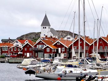 Sailboats moored in canal amidst buildings in city